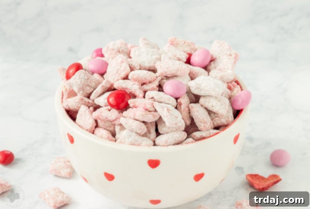 A bowl of delicious Strawberry Puppy Chow with a festive, sweet presentation