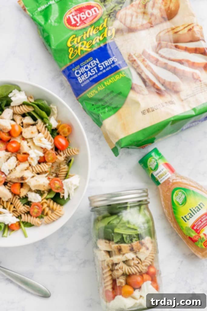 Delicious Layered Chicken Caprese Salad in a Jar, perfect for healthy meal prep and on-the-go lunches. Features fresh mozzarella, cherry tomatoes, grilled chicken, and vibrant greens.