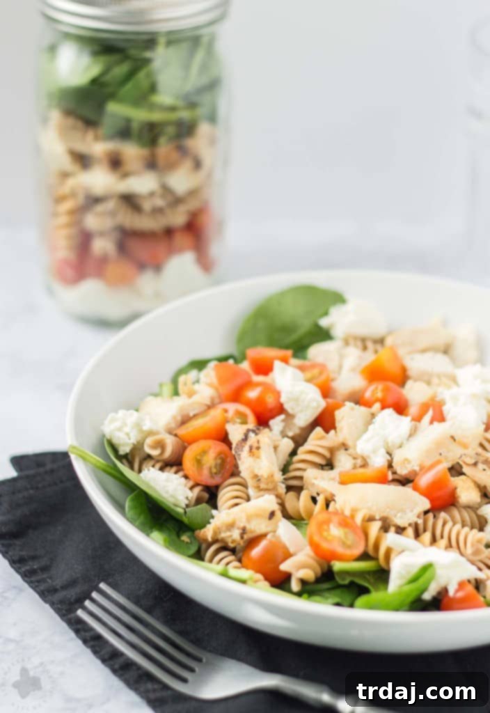 A beautifully layered Chicken Caprese Salad in a Jar, showcasing vibrant ingredients for a wholesome and convenient meal.