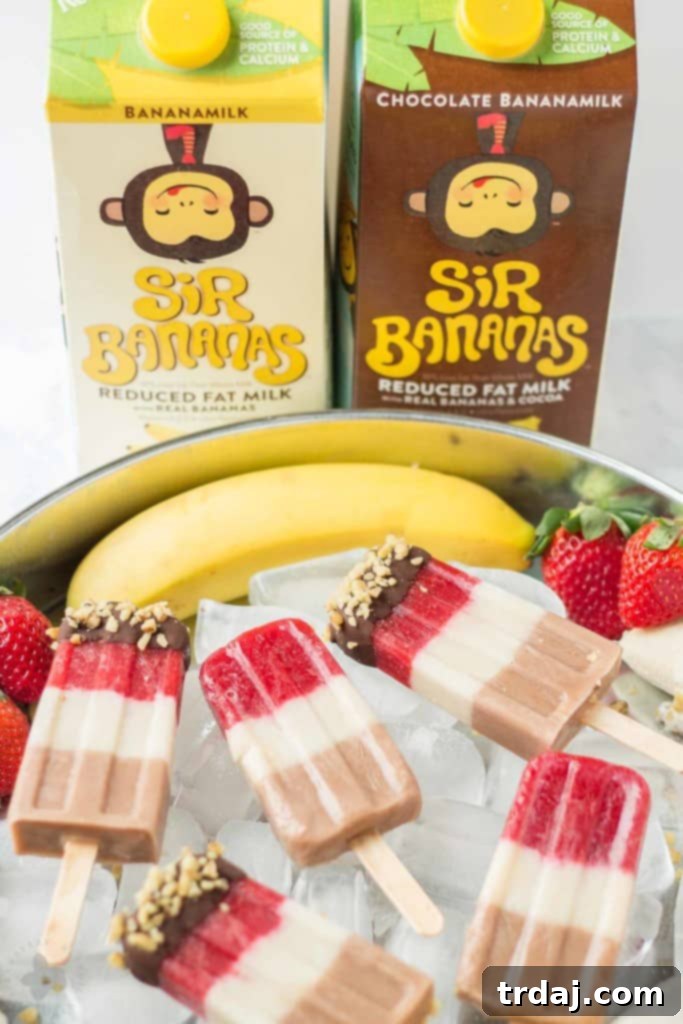 Layers of fresh strawberries, Sir BananamilkTM, and Sir Chocolate BananamilkTM make these Banana Split Popsicles irresistible to both adults and children alike. | Strawberry Blondie Kitchen