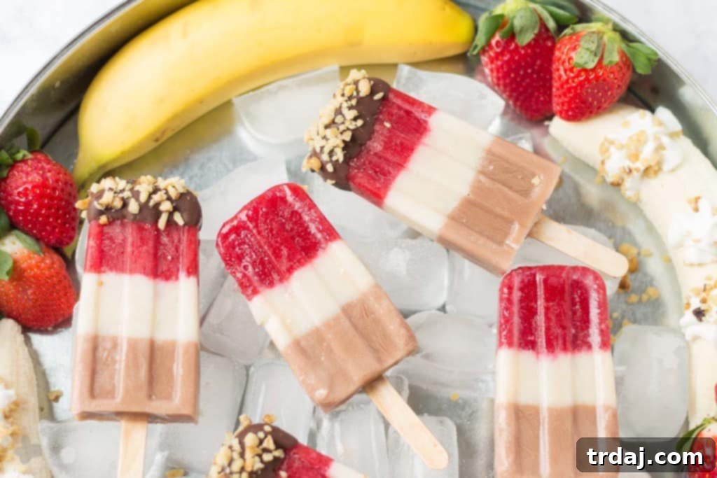 Layers of fresh strawberries, Sir BananamilkTM, and Sir Chocolate BananamilkTM make these Banana Split Popsicles irresistible to both adults and children alike. | Strawberry Blondie Kitchen