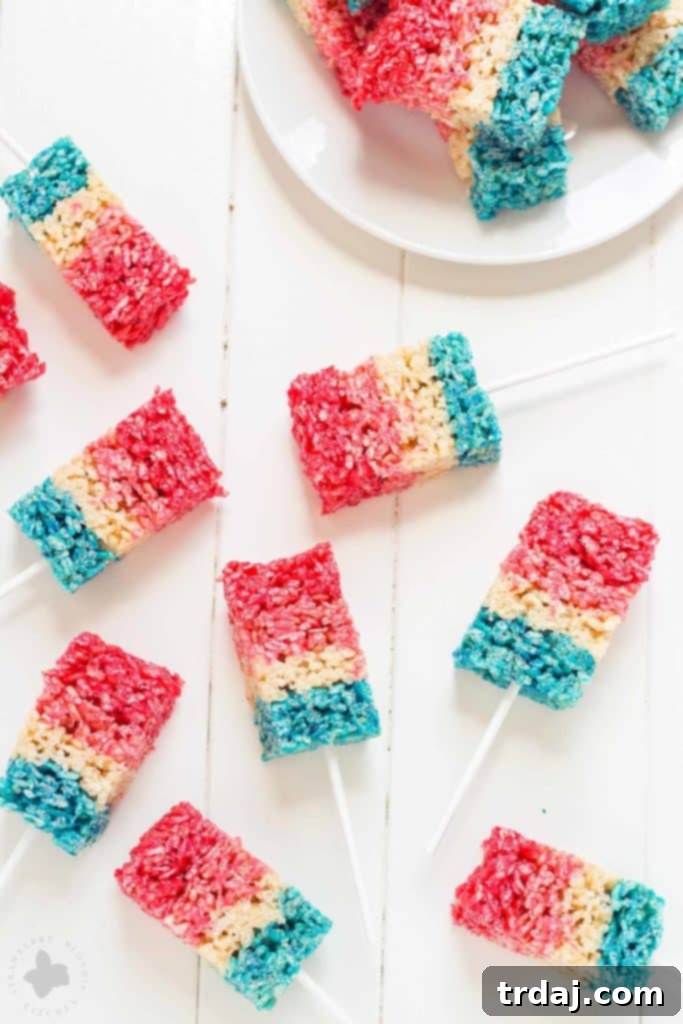 Freedom Fluffs 2 Delicious layered Patriotic Crispy Treats with strawberry, vanilla, and blue raspberry flavors, perfect for Fourth of July parties.