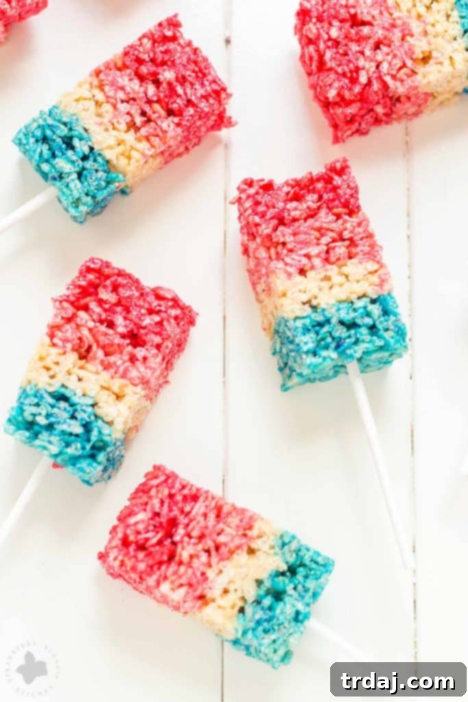 Freedom Fluffs 6 Tall, layered Patriotic Crispy Treats on sticks, resembling bomb pops, ready for serving.