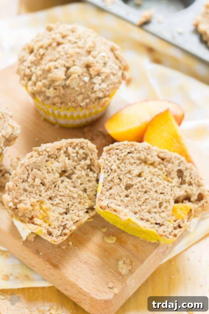 A vibrant display of baked Peach Oatmeal Crumb Muffins, beautifully arranged for serving. | Strawberry Blondie Kitchen