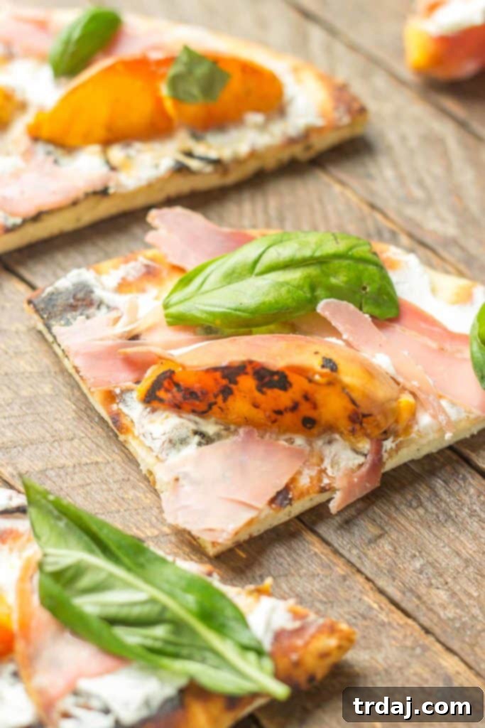 Another perspective of the artfully arranged Grilled Peach, Prosciutto, and Goat Cheese Pizza, emphasizing the fresh ingredients on a charred naan base | Strawberry Blondie Kitchen