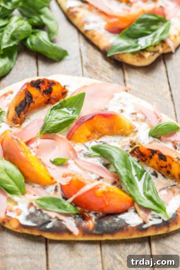 Overhead shot of the completed Grilled Peach, Prosciutto, and Goat Cheese Pizza, ready to be sliced and served, highlighting the vibrant colors and appealing textures | Strawberry Blondie Kitchen