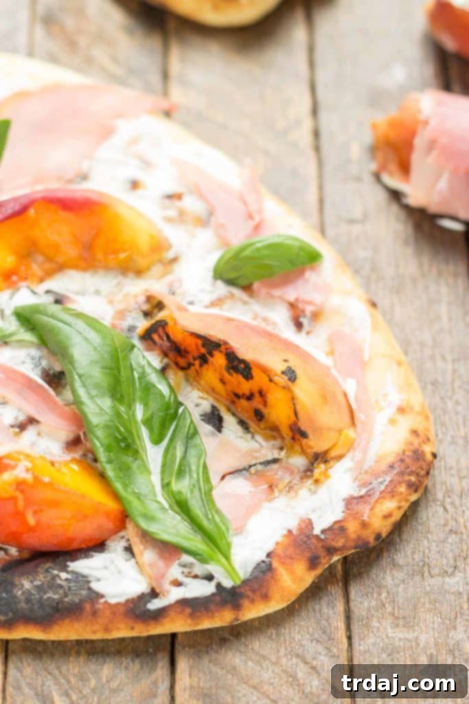 A final, mouth-watering image of the Grilled Peach, Prosciutto, and Goat Cheese Pizza, perfectly sliced and ready to be enjoyed | Strawberry Blondie Kitchen