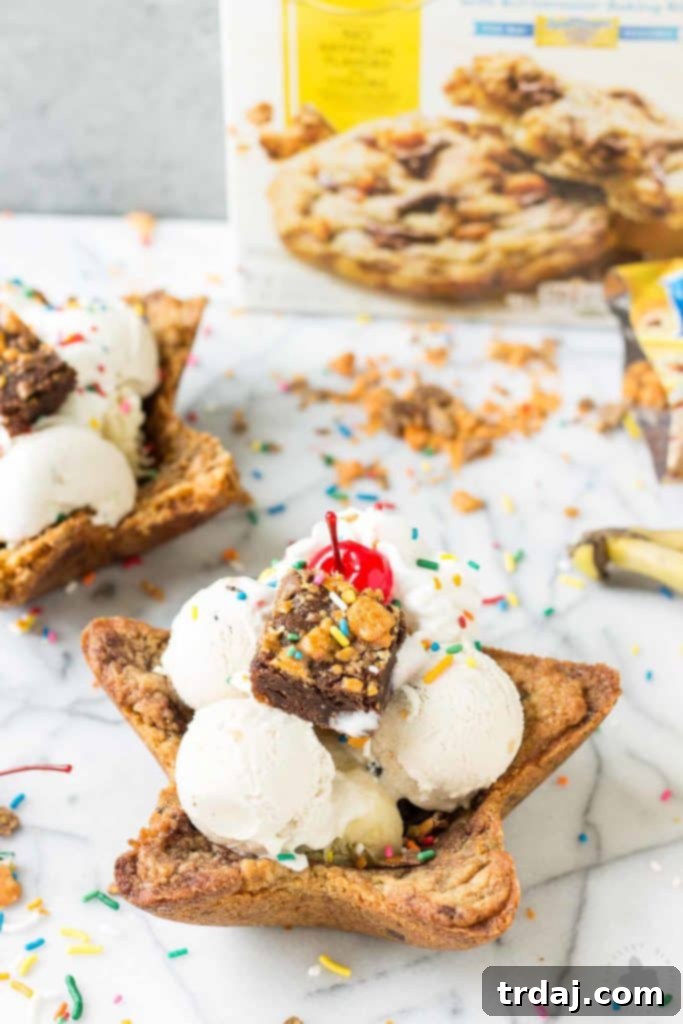 Freshly baked edible cookie bowls stacked with various ice cream flavors and vibrant toppings