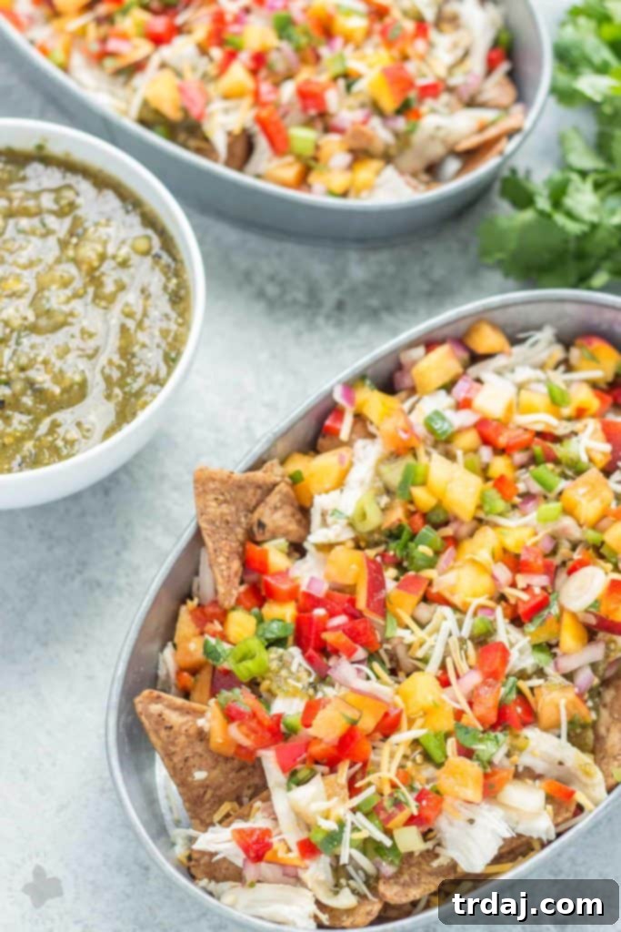 Delicious Chicken Nachos with vibrant Peach Salsa, featuring juicy peaches, fresh vegetables, perfectly cooked chicken, and a zesty tomatillo sauce for a memorable summer meal.