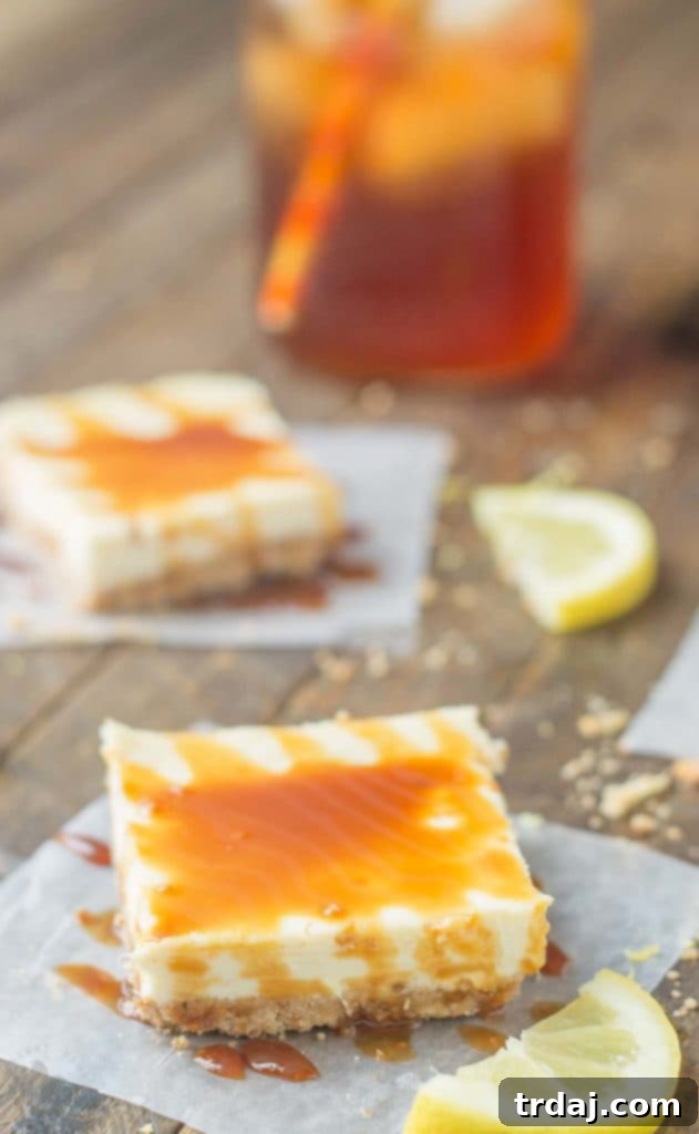 Three Arnold Palmer Cheesecake Bars artfully arranged on a serving plate, drizzled with caramel sauce.