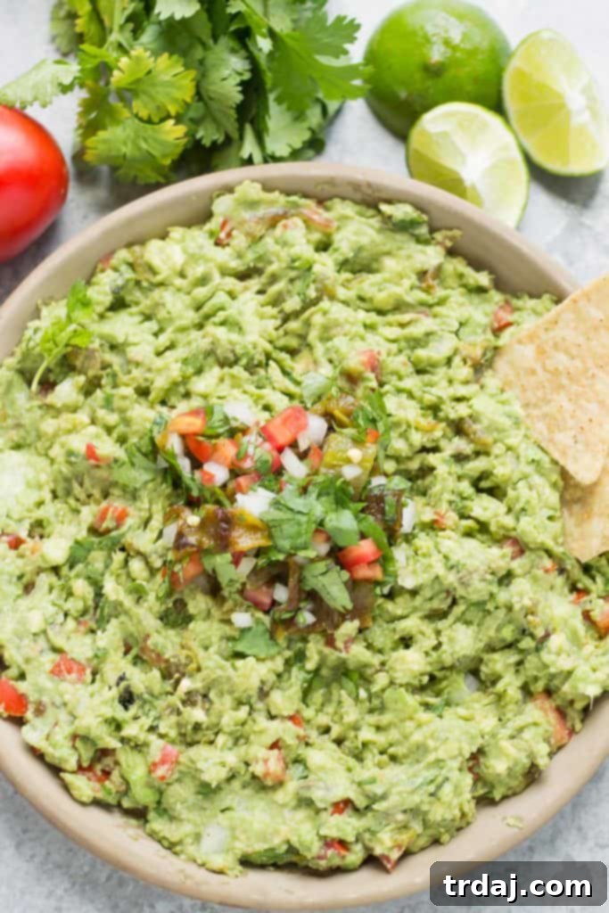 A vibrant bowl of Fire Roasted Hatch Chile Guacamole, ready to be served