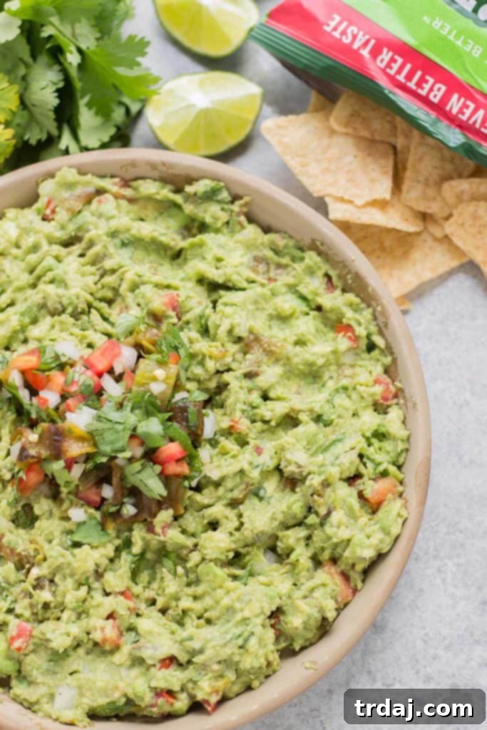 Scooping a chip into freshly made Hatch Chile Guacamole
