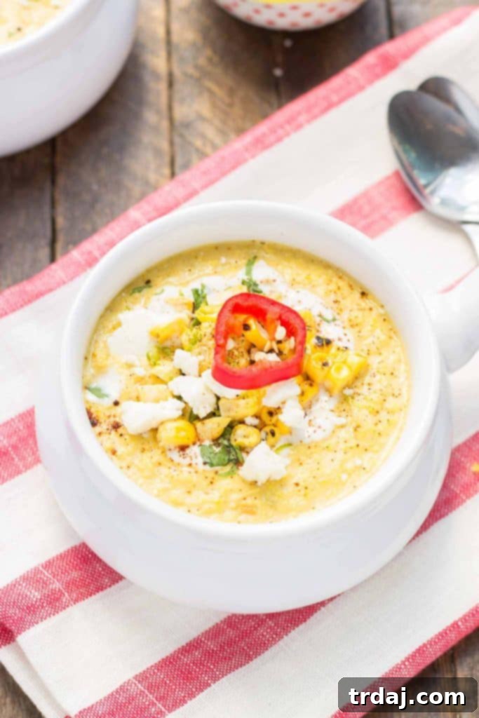 Ingredients for Mexican Street Corn Chowder laid out on a wooden cutting board, including fresh corn, lime, cilantro, and chili powder.