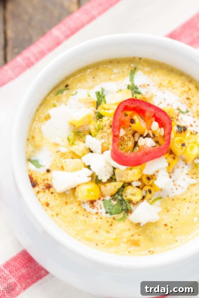 A serving of Mexican Street Corn Chowder in a white bowl, topped with vibrant green cilantro and crumbled cotija cheese, ready to be enjoyed.
