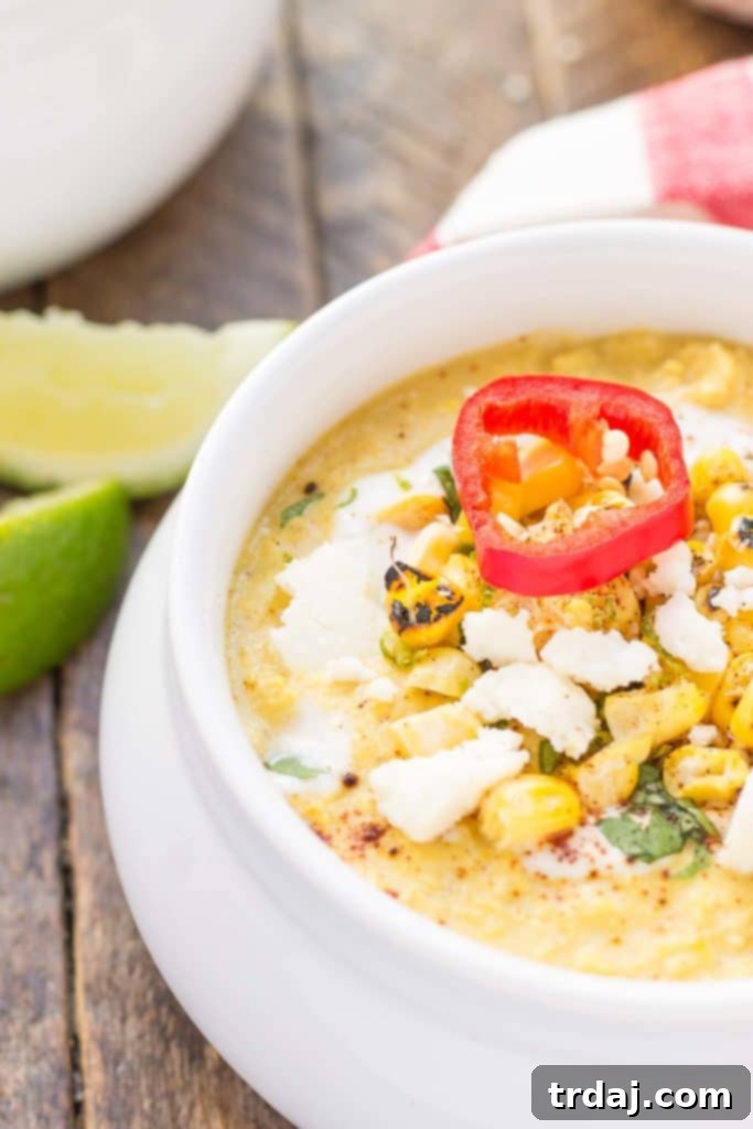 Close-up shot of Mexican Street Corn Chowder, highlighting its creamy texture and the colorful toppings of cilantro and red chili powder.