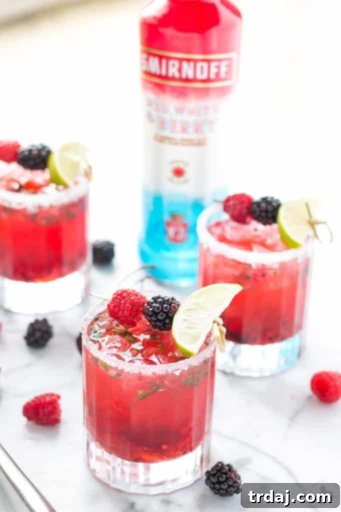 Two Triple Berry Mojitini cocktails in elegant glasses, vibrant and inviting for any outdoor party setting.
