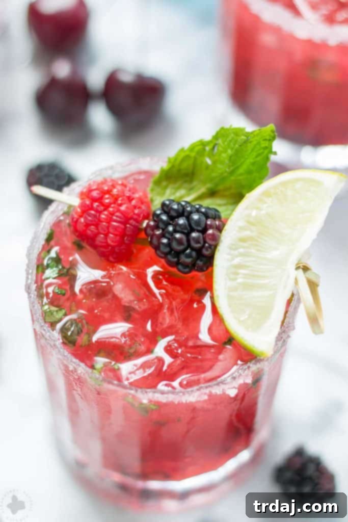 Two perfectly prepared Triple Berry Mojitinis, garnished and ready for a celebratory toast to summer's end.