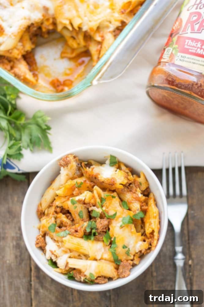 Close-up of baked mostaccioli dish with layers of pasta, meat sauce, and melted cheese, ready for serving.