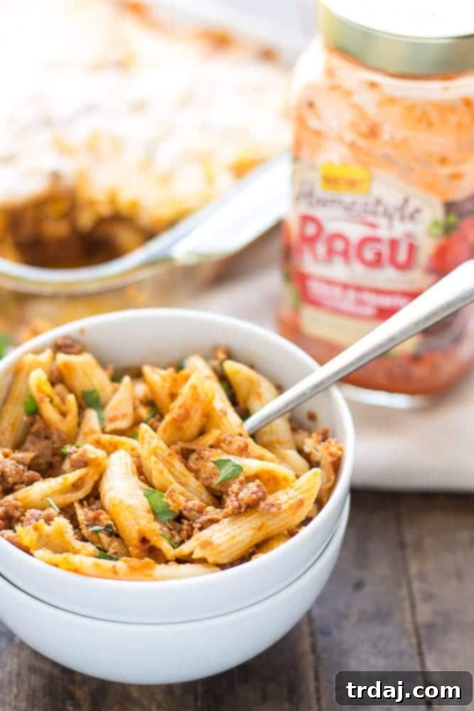 Close-up of a serving spoon scooping out a generous portion of cheesy Baked Mostaccioli.