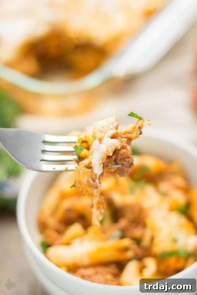 A large portion of baked mostaccioli, freshly out of the oven, with a golden-brown cheesy crust.
