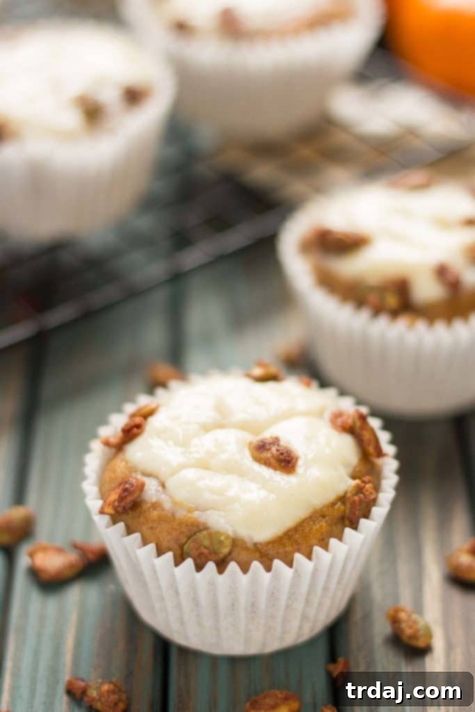 A vibrant display of freshly baked Pumpkin Spice Cream Cheese Muffins, showcasing their perfect golden-brown tops and rich filling. | Strawberry Blondie Kitchen
