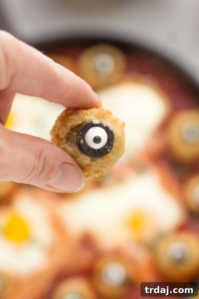 Eggs are baked in a tomato sauce and then breaded mushrooms with sliced black olives, made to looks like eyes, are nestled alongside to create this Halloween Eyeball Skillet. A festive meal sure to please the entire family! | Strawberry Blondie Kitchen