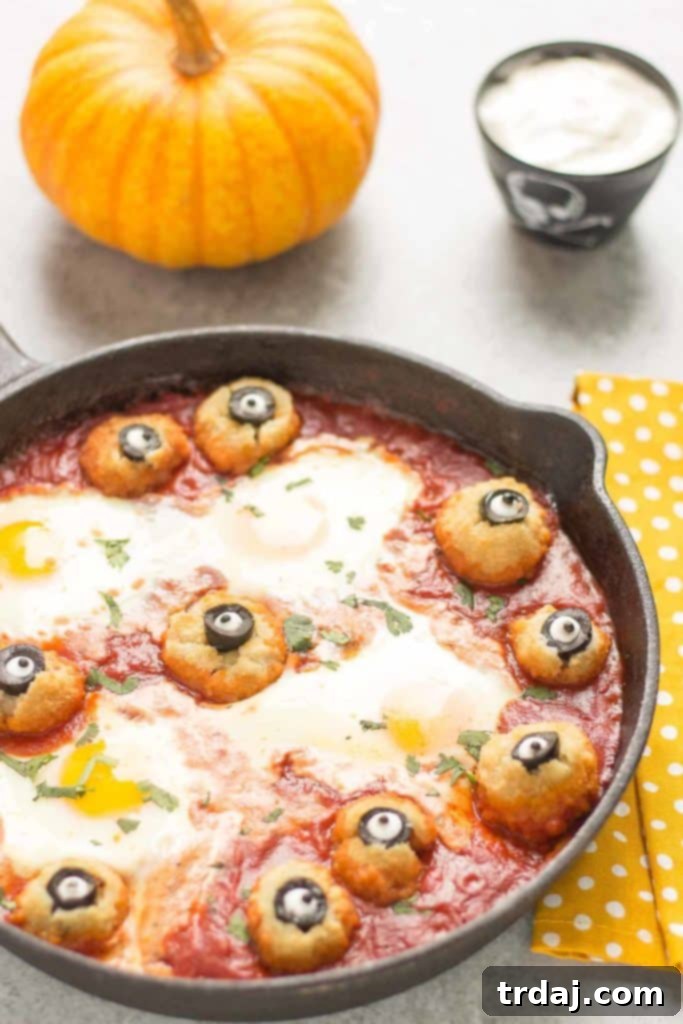 Eggs are baked in a tomato sauce and then breaded mushrooms with sliced black olives, made to looks like eyes, are nestled alongside to create this Halloween Eyeball Skillet. A festive meal sure to please the entire family! | Strawberry Blondie Kitchen