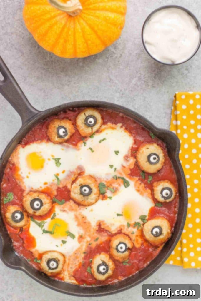 Eggs are baked in a tomato sauce and then breaded mushrooms with sliced black olives, made to looks like eyes, are nestled alongside to create this Halloween Eyeball Skillet. A festive meal sure to please the entire family! | Strawberry Blondie Kitchen