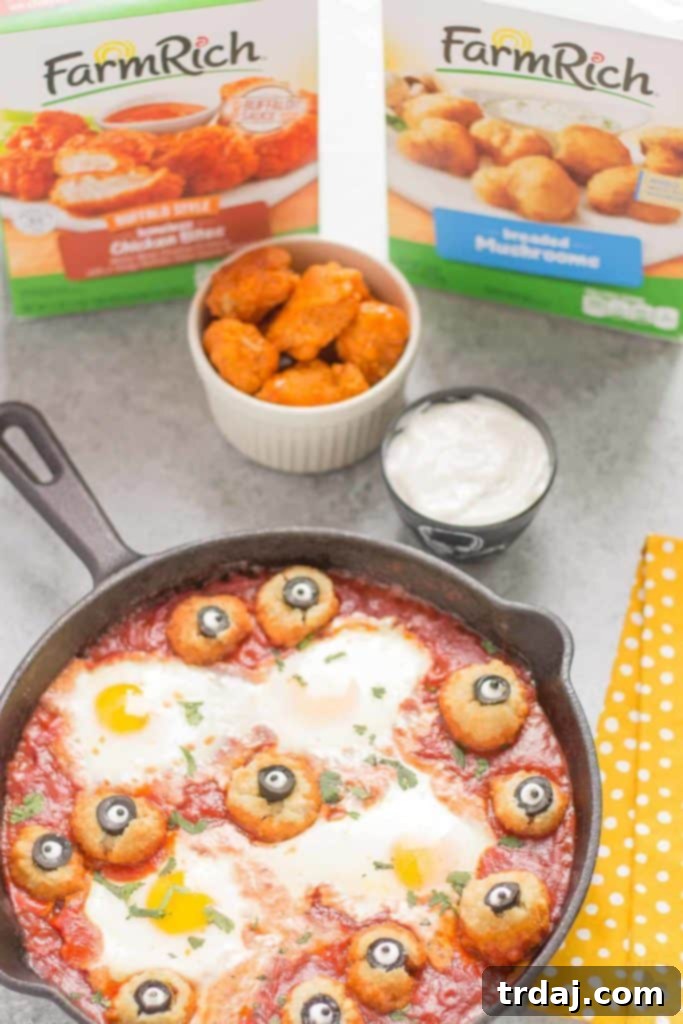 Eggs are baked in a tomato sauce and then breaded mushrooms with sliced black olives, made to looks like eyes, are nestled alongside to create this Halloween Eyeball Skillet. A festive meal sure to please the entire family! | Strawberry Blondie Kitchen