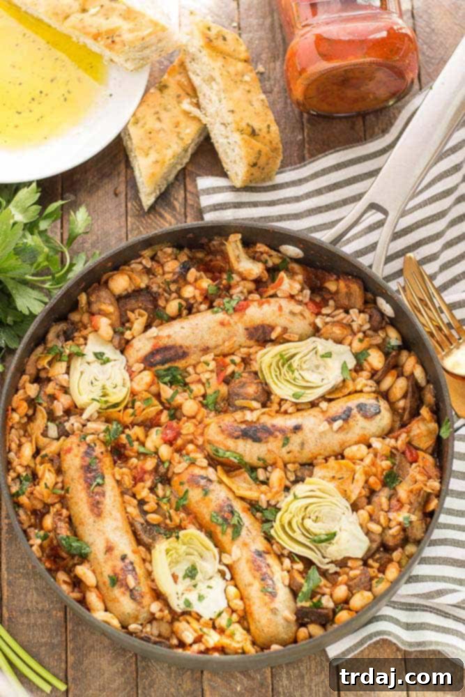 Delicious One-Pan Tuscan Italian Sausages with Bertolli sauce, cannellini beans, mushrooms, artichokes, and farro on a rustic plate, ready to serve.
