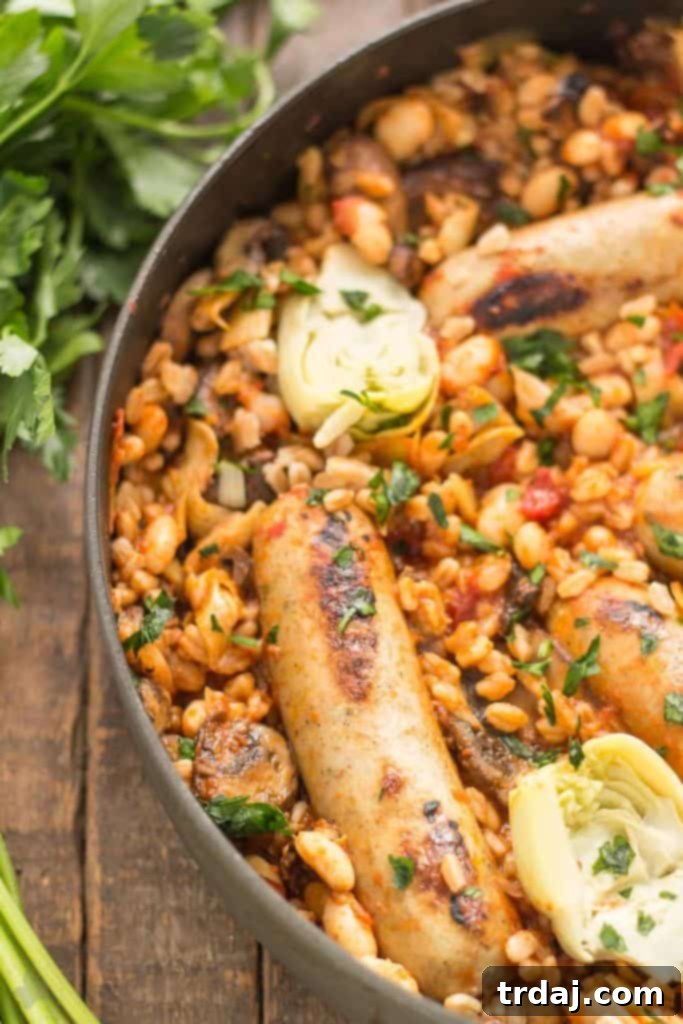 Plated One-Pan Tuscan Italian Sausages with a generous serving of farro, beans, and vegetables, garnished with fresh basil.