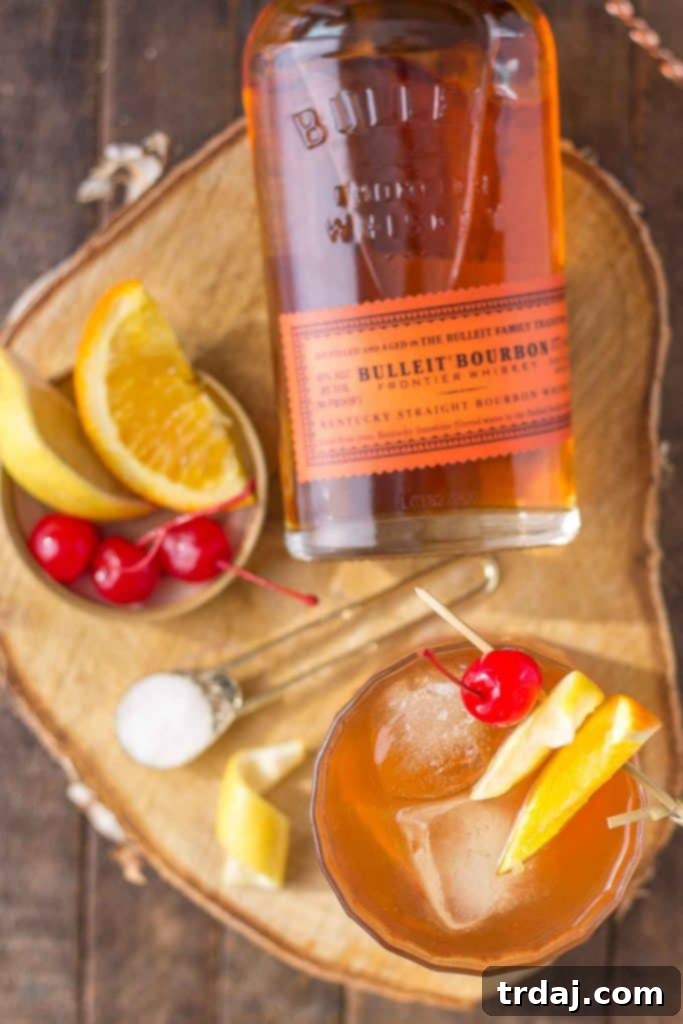 A Black Walnut Old Fashioned cocktail with bourbon, ice, and an orange slice garnish.