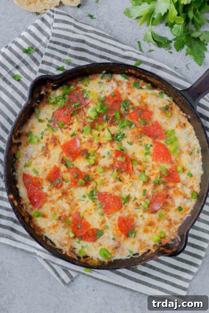 Close-up of Supreme Pizza Dip with melted cheese and pepperoni, ready to scoop.