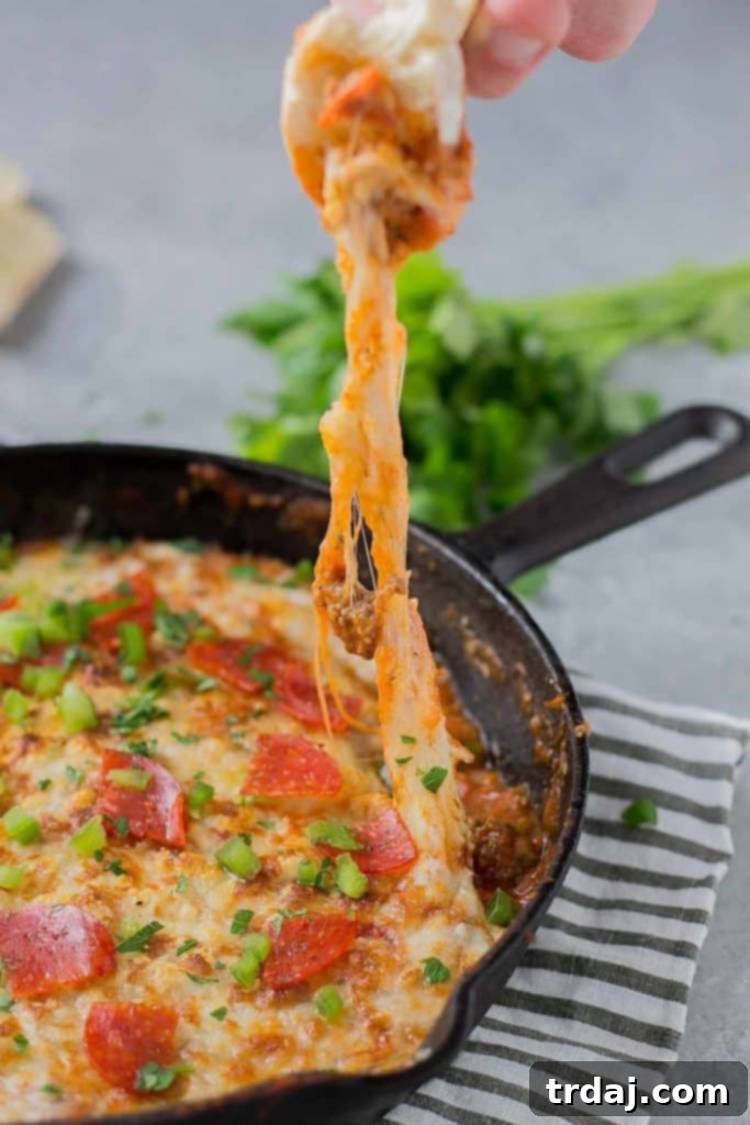 Bubbling Supreme Pizza Dip fresh from the oven, showing off its cheesy texture.