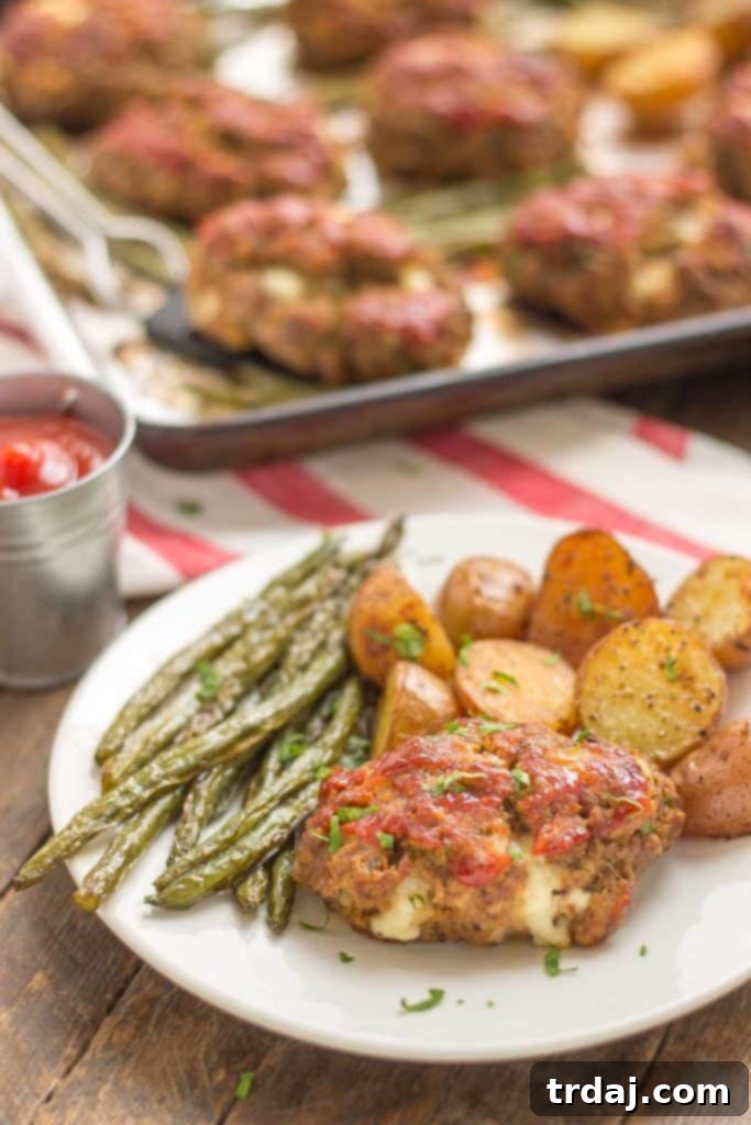 Sheet Pan Mini Meatloaves with Potatoes and Green Beans: The ultimate easy and delicious comfort food, cooked on one pan. Sheet Pan Mini Meatloaves with Potatoes and Green Beans plated on a white dish, showcasing a perfect portion of comfort food.
