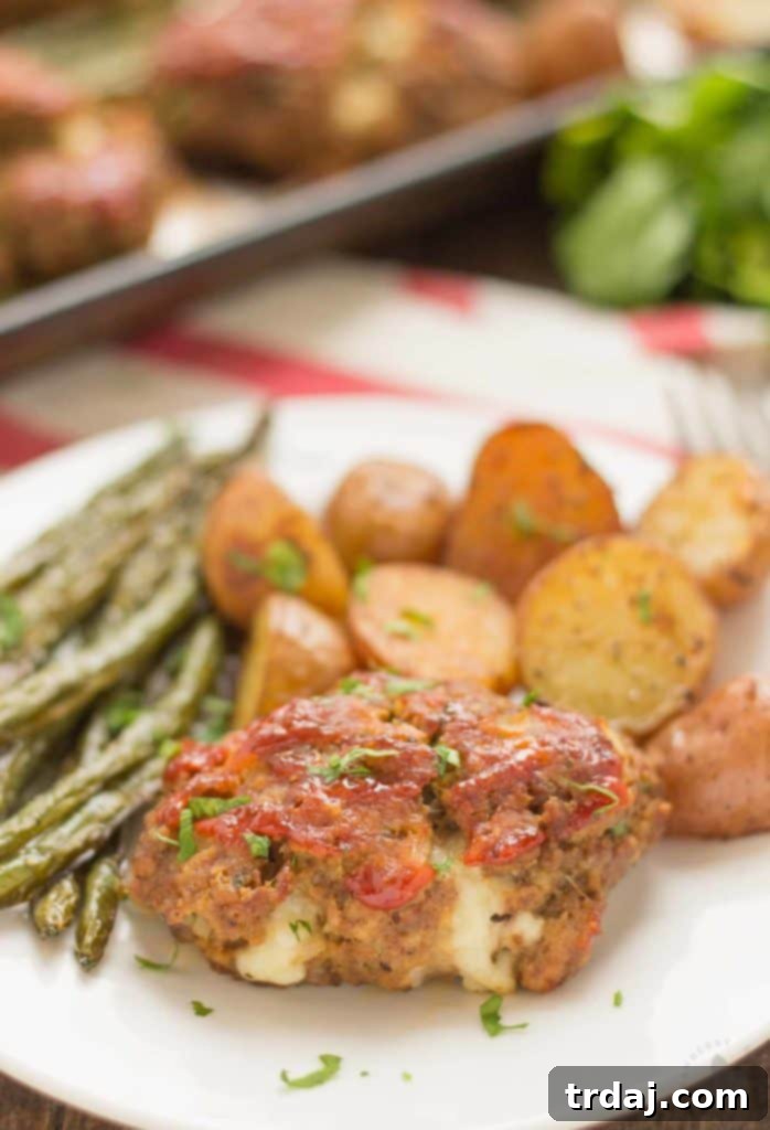 Sheet Pan Mini Meatloaves with Potatoes and Green Beans: Enjoy a wholesome and flavorful meal, beautifully plated and ready to savor. A perfectly plated serving of Sheet Pan Mini Meatloaves with Potatoes and Green Beans on a white dish, showcasing a balanced and appealing meal.