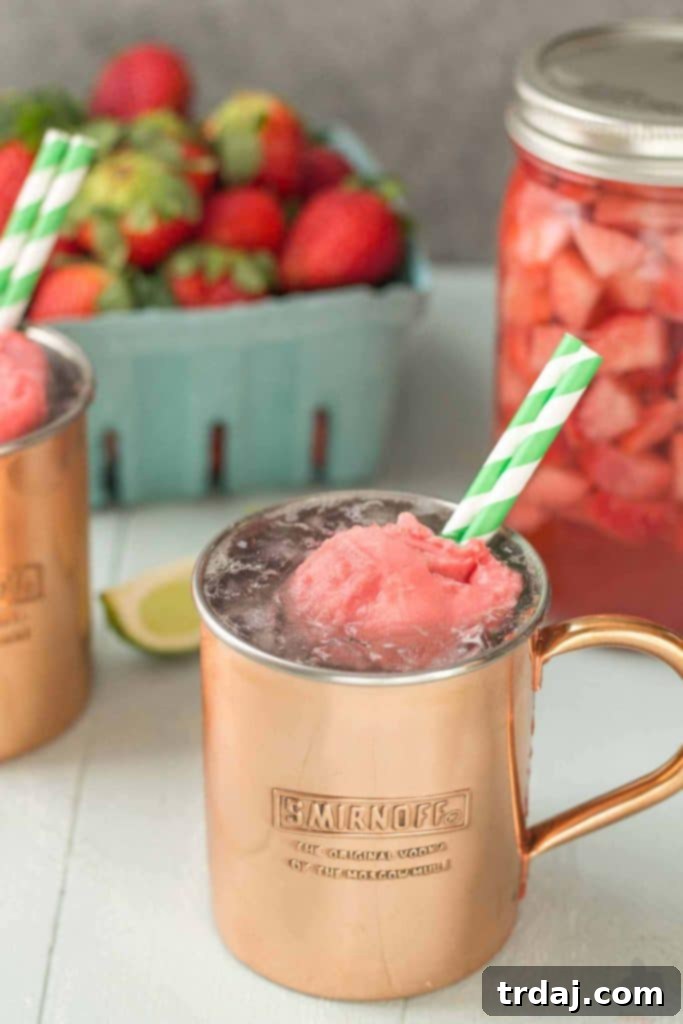 Close-up of a Strawberry Moscow Mule Float, showcasing the rich red color and the melting strawberry sorbet, creating a creamy texture.