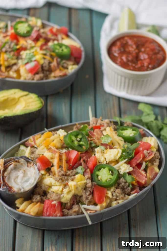 The B.E.S.T Breakfast Nachos layered with sausage, egg, bacon, melted cheese, and fresh tomatoes.