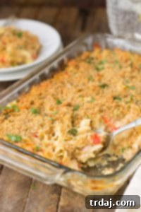 A close-up shot of the finished Lightened Up Cheesy Tuna Noodle Casserole, with a scoop removed to show its creamy texture.