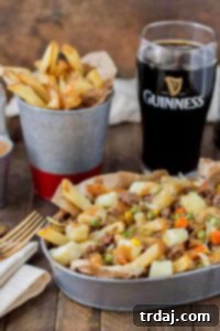 Crispy fries piled high with beef and mixed vegetables, smothered in Guinness gravy and topped with cheese curds make for one awesome Shepherd's Pie Poutine. | Strawberry Blondie Kitchen
