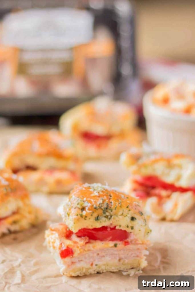 Irresistible Kentucky Hot Brown Turkey Sliders: The quintessential appetizer for your Kentucky Derby Party, boasting Castle Wood Reserve® turkey, pimento cheese, bacon, and fresh tomatoes. Delicious Kentucky Hot Brown Turkey Sliders arranged on a serving tray, perfect for a Kentucky Derby party appetizer.