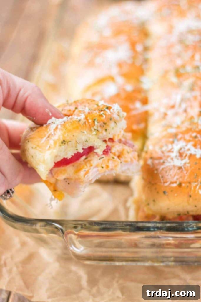 A close-up view of our amazing Kentucky Hot Brown Turkey Sliders, perfect for a Derby party: featuring premium turkey, homemade pimento cheese, bacon, and juicy tomatoes. Close-up of golden-brown Kentucky Hot Brown Turkey Sliders, ready to be served as a delightful Kentucky Derby appetizer.