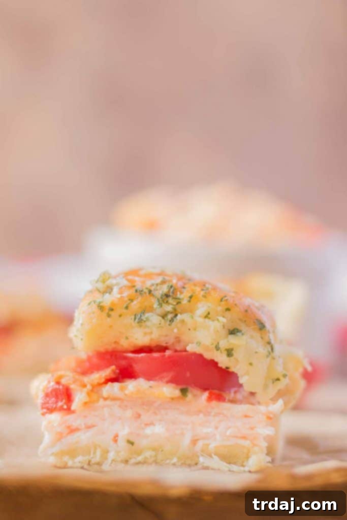 Indulge in the best Kentucky Hot Brown Turkey Sliders – the ideal savory snack for any Kentucky Derby Party! A serving of Kentucky Hot Brown Turkey Sliders, showcasing the layers of turkey, bacon, tomato, and pimento cheese.