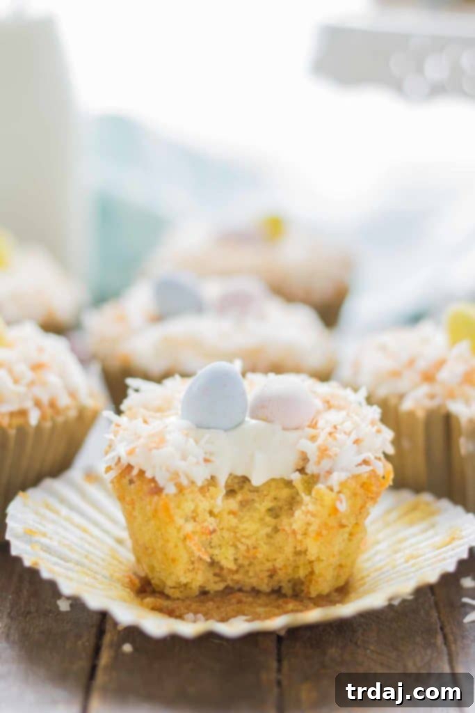 Close-up of Pineapple Carrot Cake Cupcakes decorated with sweet cream cheese frosting and toasted coconut flakes