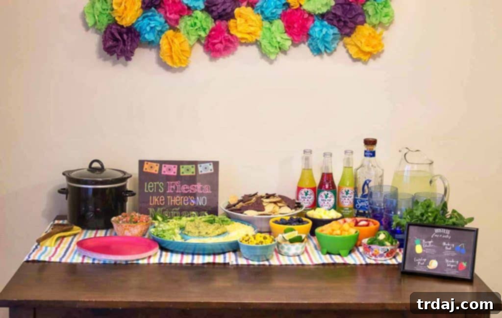 Festive spread of Mexican appetizers, fresh ingredients for a margarita bar, and Sauza Tequila bottles, set on a colorful table for a Cinco de Mayo party.