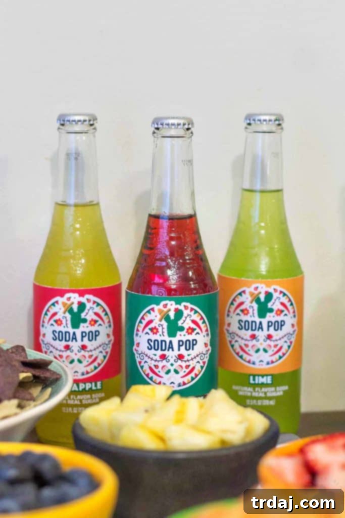 Assortment of vibrant Mexican soft drinks with playful 'Soda Pop' labels, providing non-alcoholic options for party guests.