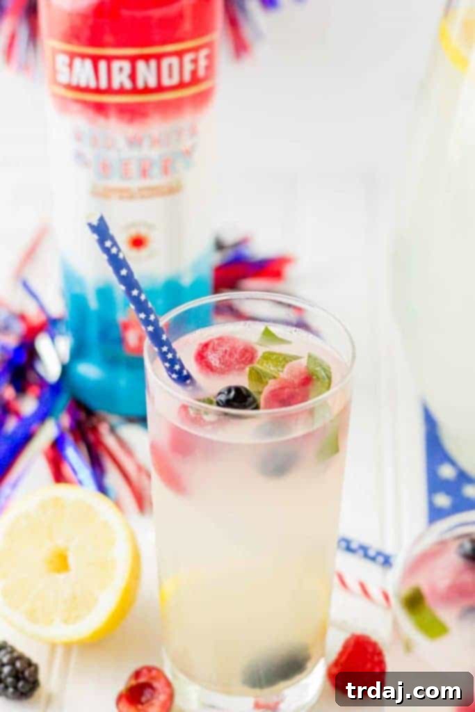 Close-up of a Spiked Triple Berry Basil Lemonade cocktail garnished with fresh berries and basil, showcasing its vibrant colors and refreshing appeal.