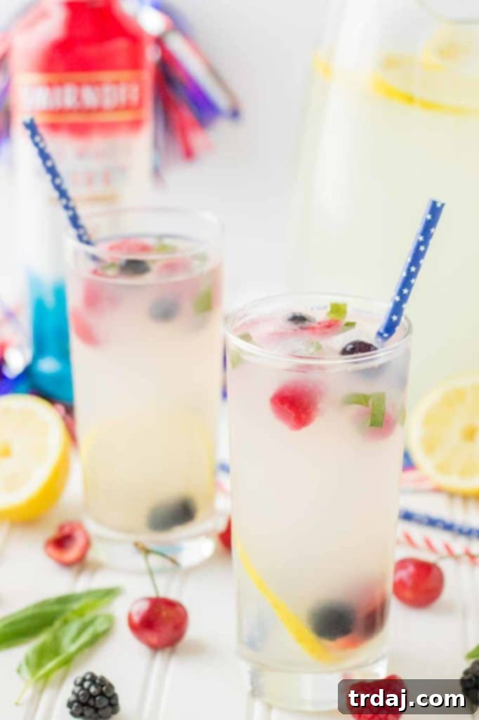 Refreshing Spiked Triple Berry Basil Lemonade in a glass, ready for a summer party.