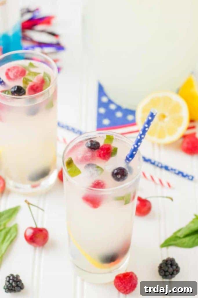 A high-angle shot of a Spiked Triple Berry Basil Lemonade cocktail, showing its beautiful layers and garnishes.