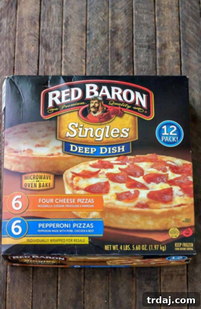 Hand holding a slice of perfectly grilled deep dish pepperoni pizza from Red Baron.